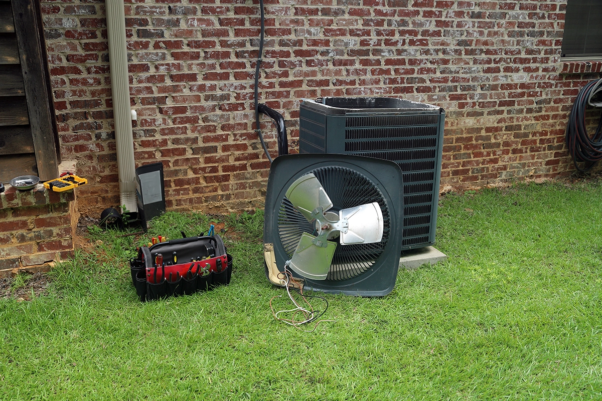 Technician inspecting residential air conditioner outdoor unit